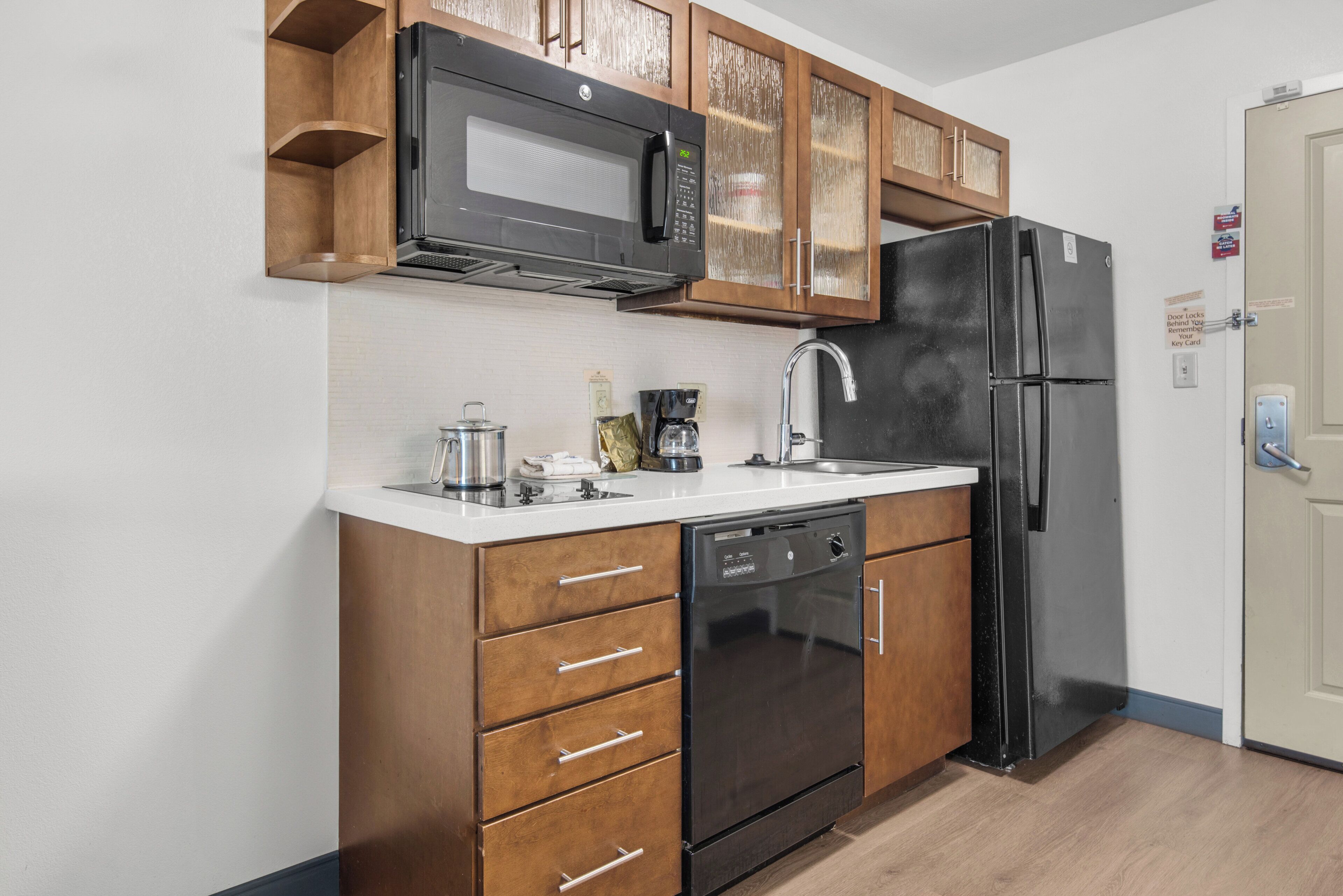 A compact kitchen with a microwave, refrigerator, and dishwasher.