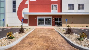 A building with a large red arrow sign, a parking lot, and a wheelchair-accessible entrance. - Days Inn by Wyndham South Bend / Notre Dame (South Bend)