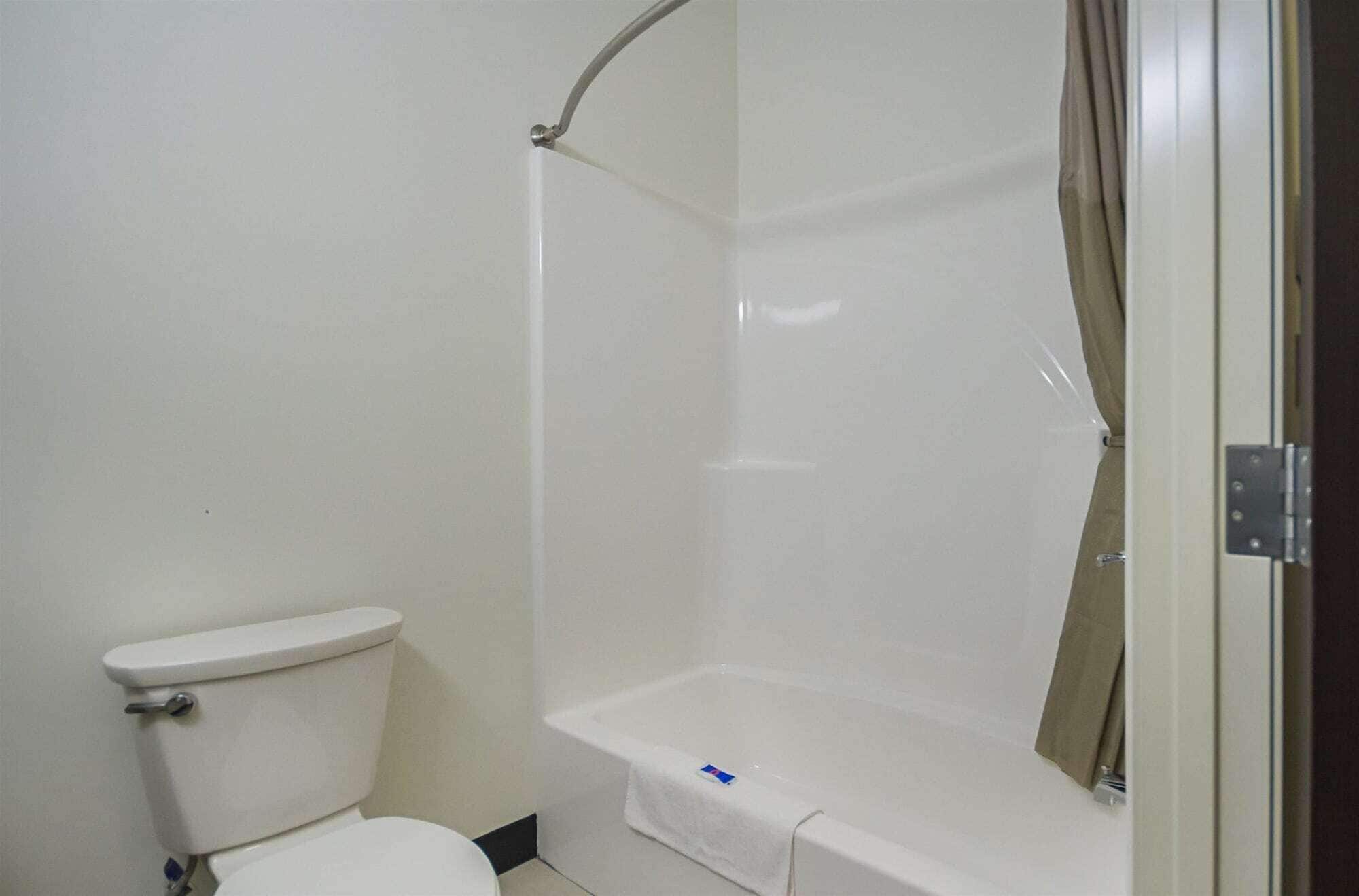 A bathroom with a toilet, a bathtub, and a shower enclosure.