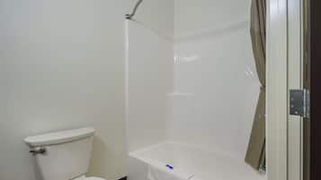 A bathroom with a toilet, a bathtub, and a shower enclosure.