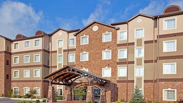 A multi-story hotel with a brick facade, multiple windows, and a covered entrance area.