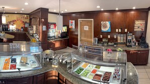 A buffet area with various food options and a Coca-Cola refrigerator. - Staybridge Suites Elkhart North by IHG (Elkhart)
