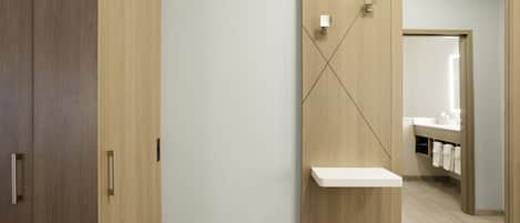 Un baño con tocador de madera, un espejo y un perchero para toallas.
