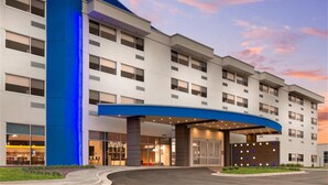 A multi-story hotel with a curved entrance canopy, large windows, and a modern design. - Holiday Inn Express Lexington - Horse Park Area by IHG (Lexington)