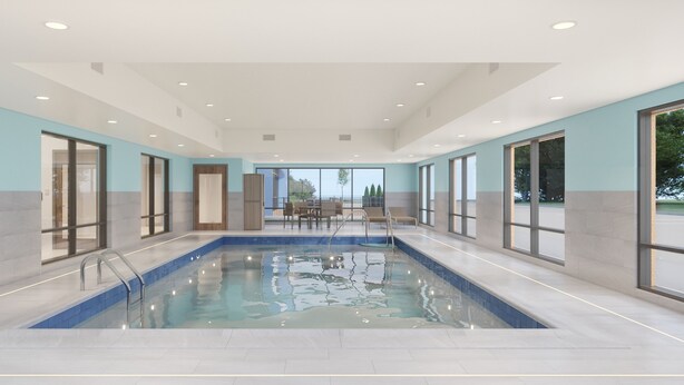 A large indoor swimming pool with a tiled floor, surrounded by large windows and a seating area with tables and chairs. - Holiday Inn Express Lexington - Horse Park Area by IHG (Lexington)