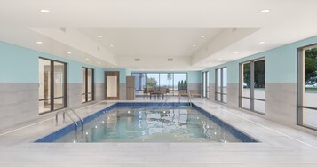 Una piscina techada, sillones reclinables de piscina
