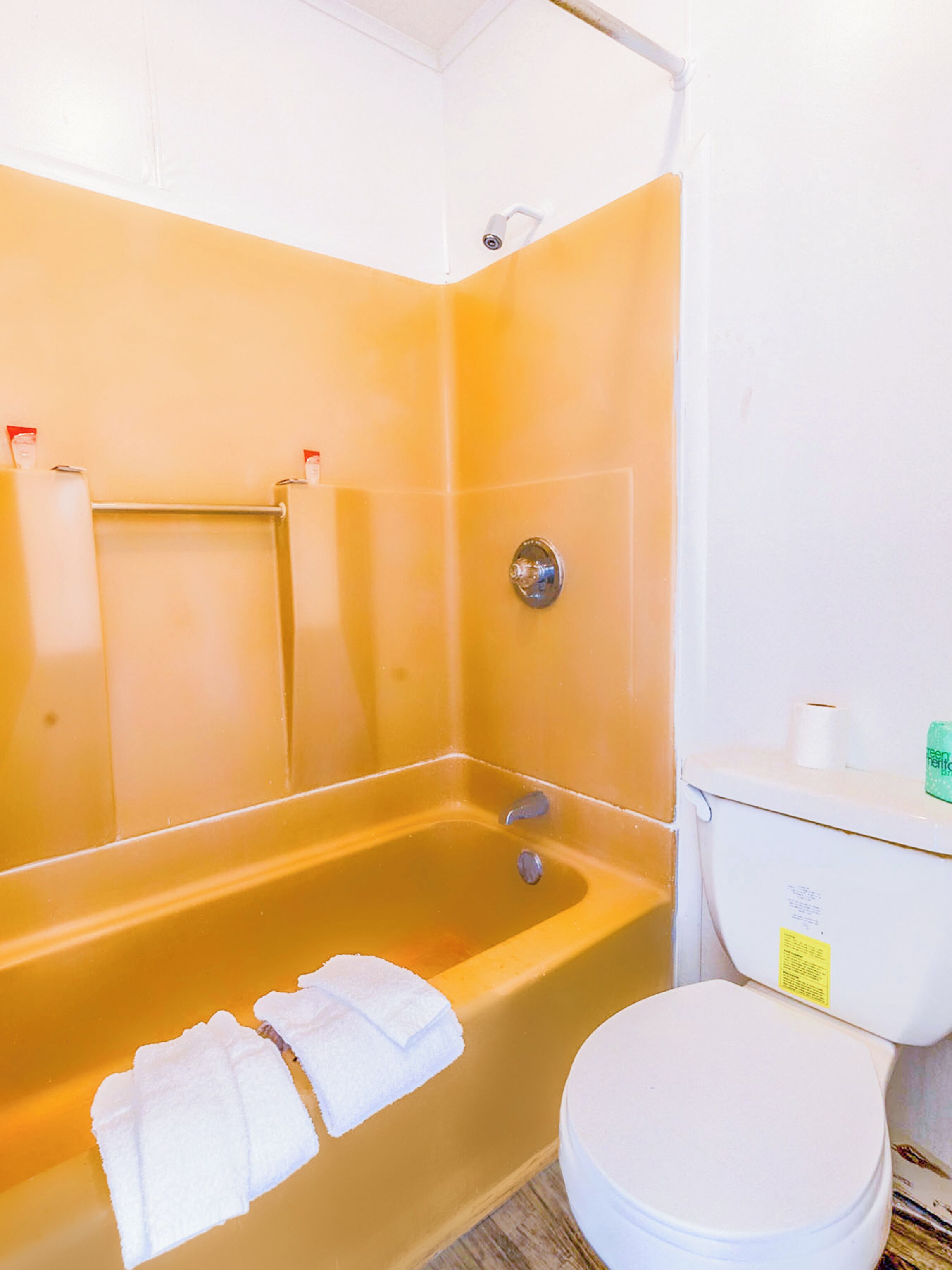 A bathroom with a bathtub, toilet, and a towel rack.