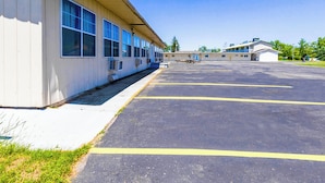 A large, single-story motel with a parking lot and a building with multiple windows and a flat roof. - Country Hearth Inn & Suites By OYO Sturgis (Sturgis)