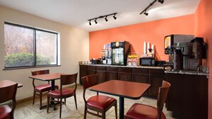 A restaurant with a kitchen counter, seating area, and a window with a view of trees. - Super 8 by Wyndham Charlotte University (Charlotte)