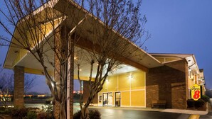 A Super 8 hotel with a covered entrance, brick facade, and a parking lot. - Super 8 by Wyndham Charlotte University (Charlotte)