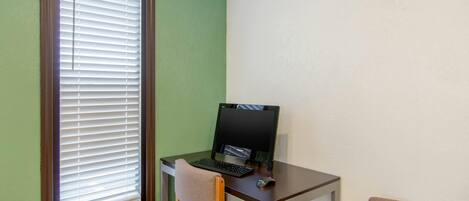 Ein kleiner Büroraum mit Schreibtisch, Computer und Stuhl.