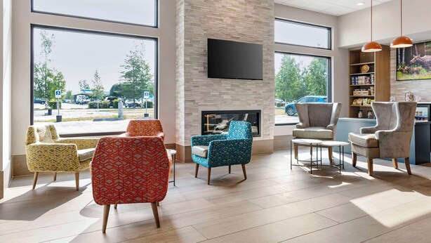 A spacious lobby with large windows, a fireplace, and comfortable seating areas. - Comfort Inn Fairbanks (Fairbanks)