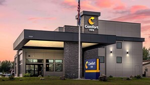 A modern Comfort Inn hotel with a flat roof, large windows, and a prominent American flag. - Comfort Inn Fairbanks (Fairbanks)
