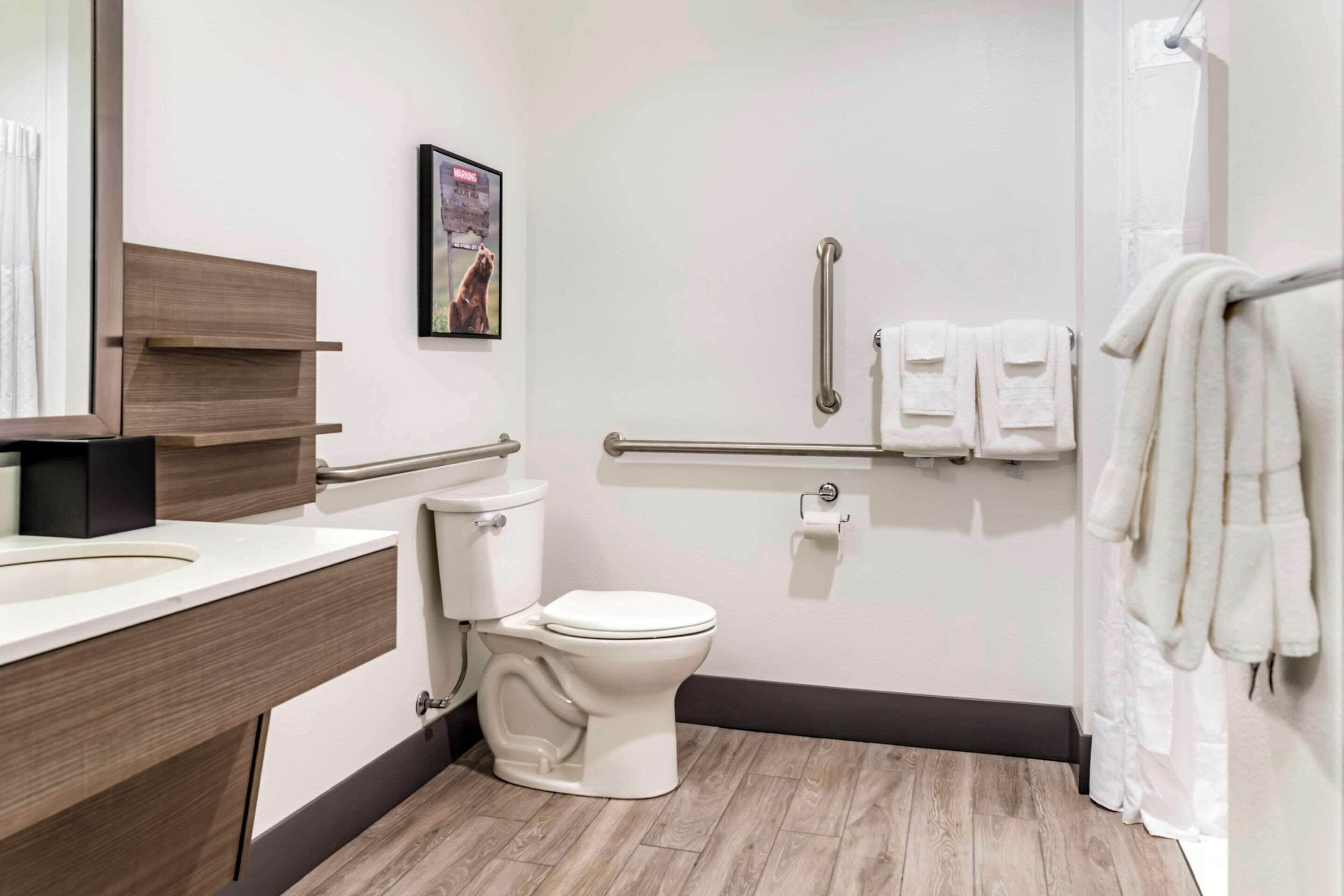 A modern bathroom with a toilet, sink, and shower area.