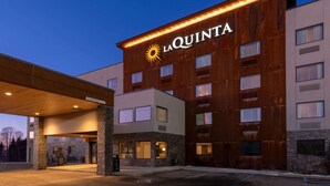 A hotel with a modern design, featuring a prominent 'La Quinta' sign and a covered entrance area.