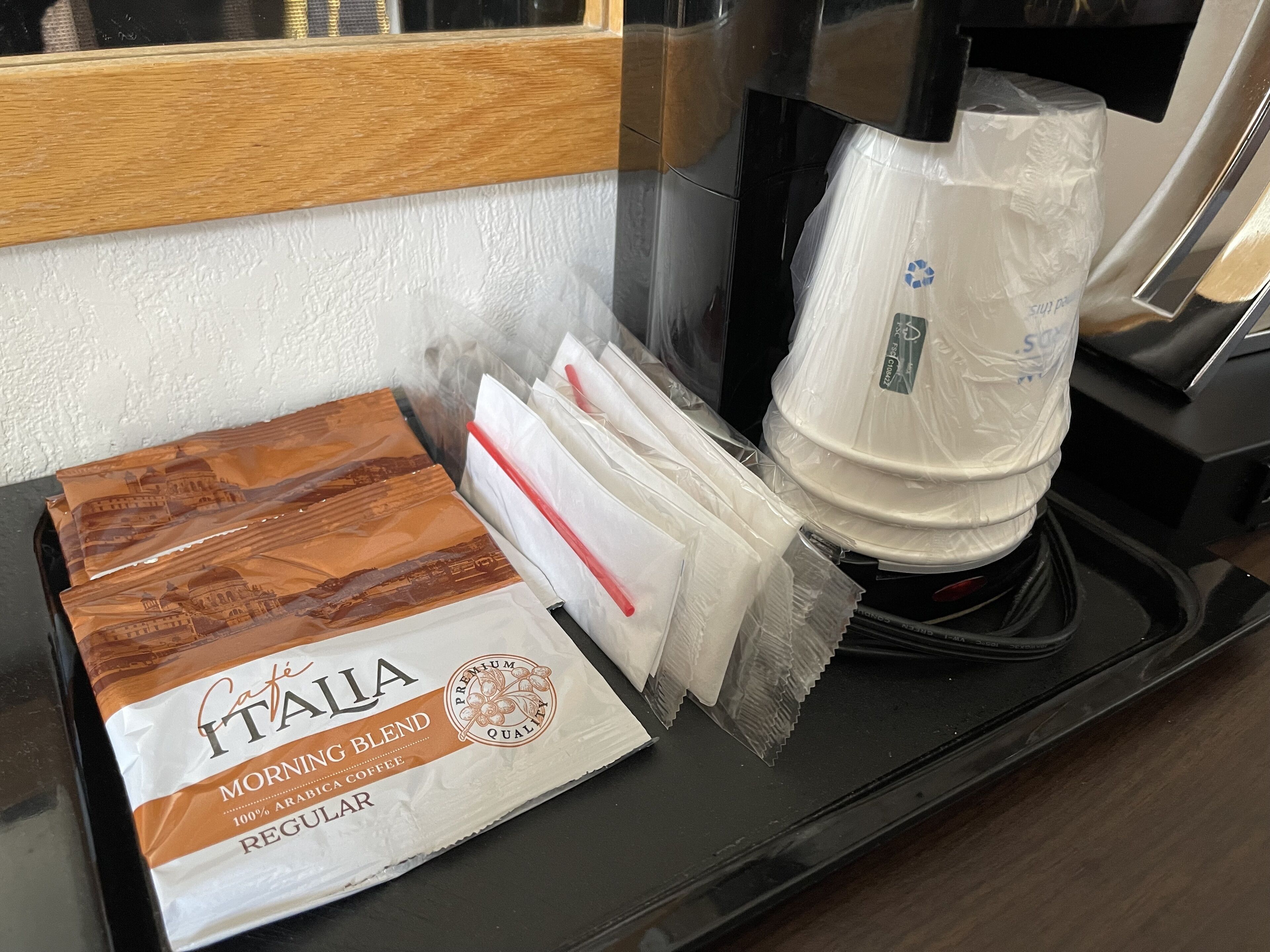 Eine Kaffeemaschine mit einer Kaffeekapsel und einer mit 'Caffe Italia Morning Blend' beschrifteten Kaffeetüte.