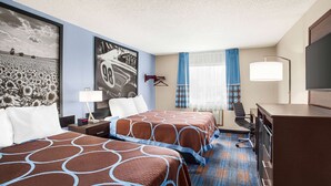 A hotel room with two beds, a desk, a TV, and a large window with curtains.