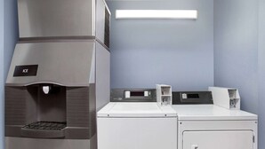 A compact laundry facility with a built-in washer and dryer, a ventilation hood, and a control panel.