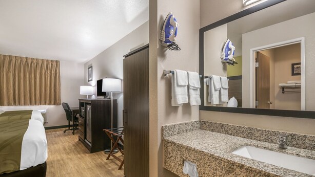 A hotel room with a bed, desk, chair, and a large mirror above the sink. - Motel 6 Lancaster, PA (Lancaster)