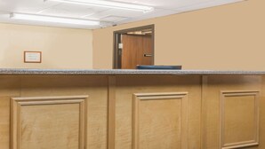 Un espace d’accueil comprenant un comptoir, un lambris en bois et une porte portant l’inscription « GESTION ».