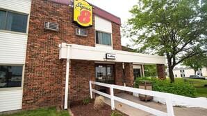Un bâtiment en briques avec une enseigne « Super 8 » et une autre indiquant « Réception ».