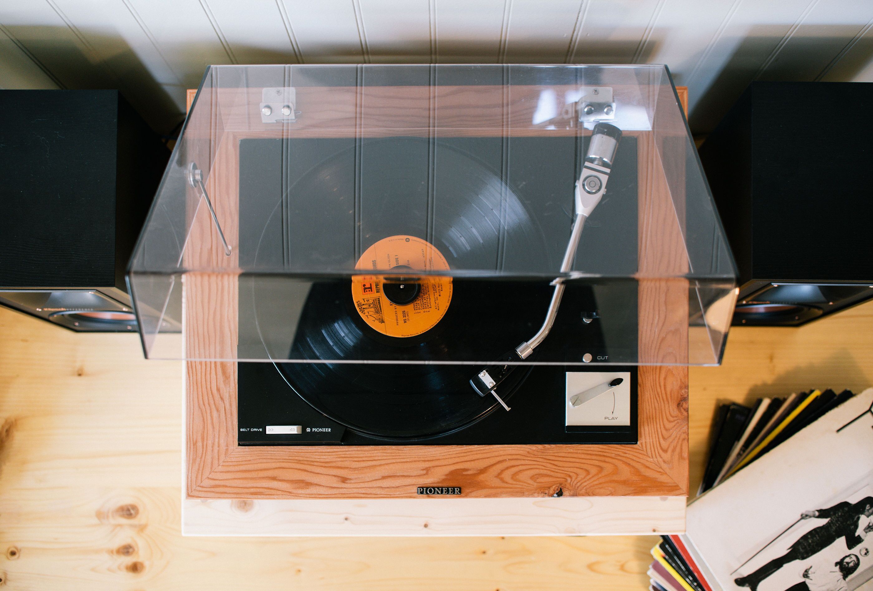 Tocadiscos Pioneer con cubierta transparente sobre una superficie de madera.