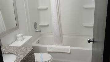Un baño con inodoro, lavamanos, ducha y bañera.