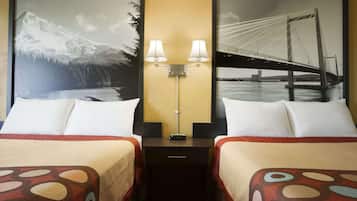 A hotel room with two beds, each with a patterned bedspread, a nightstand with a lamp, and two framed pictures on the wall.