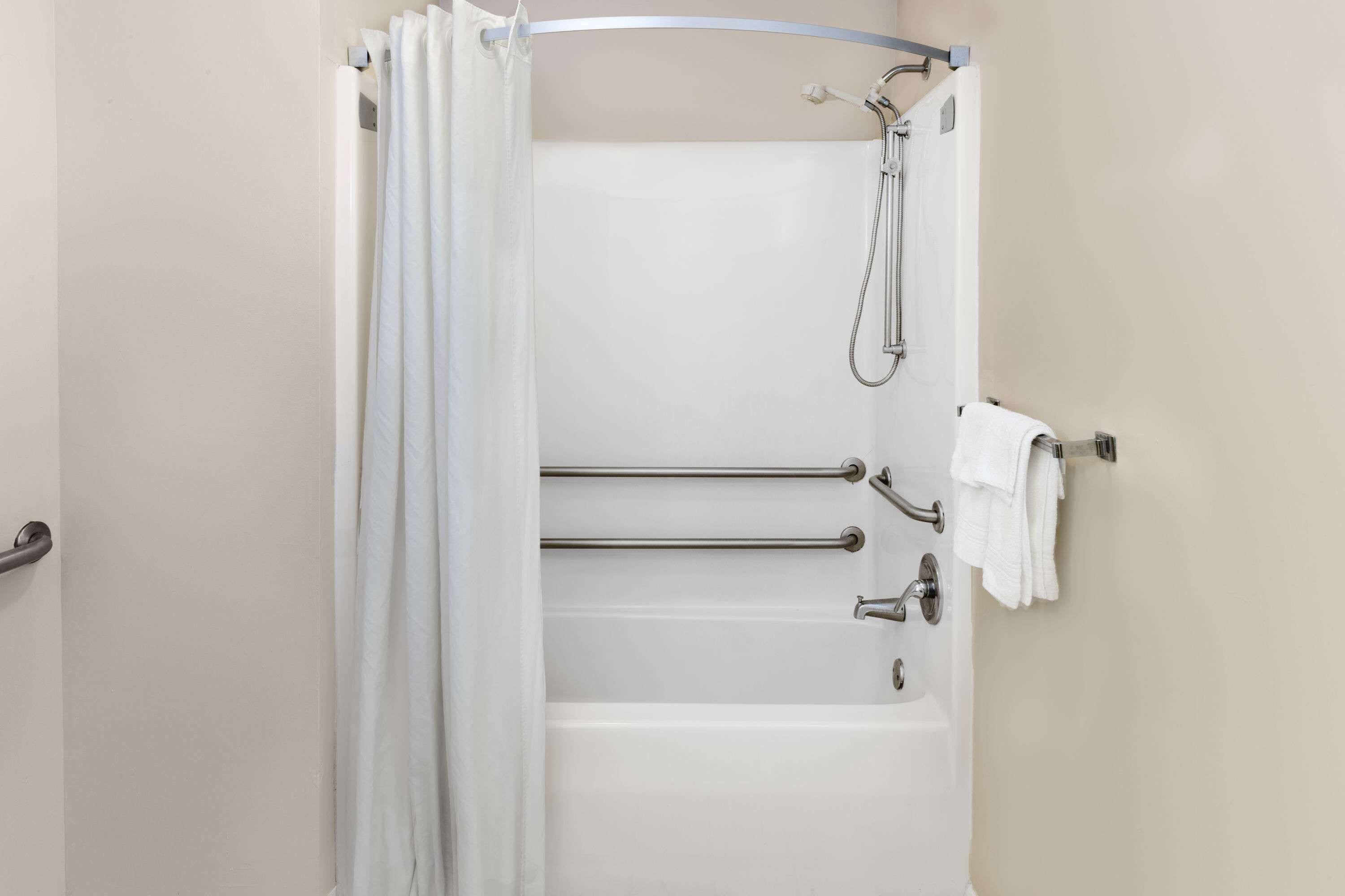 A bathroom with a bathtub, a shower, and a towel rack.