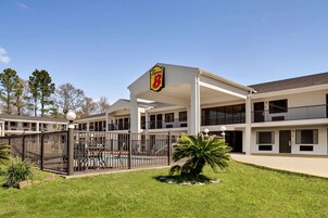 Un hotel con piscina, un patio cubierto y un letrero que indica que es un Super 8.