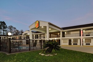 Un motel con piscina, un patio cercado y un letrero que indica que es un hotel Super 8.