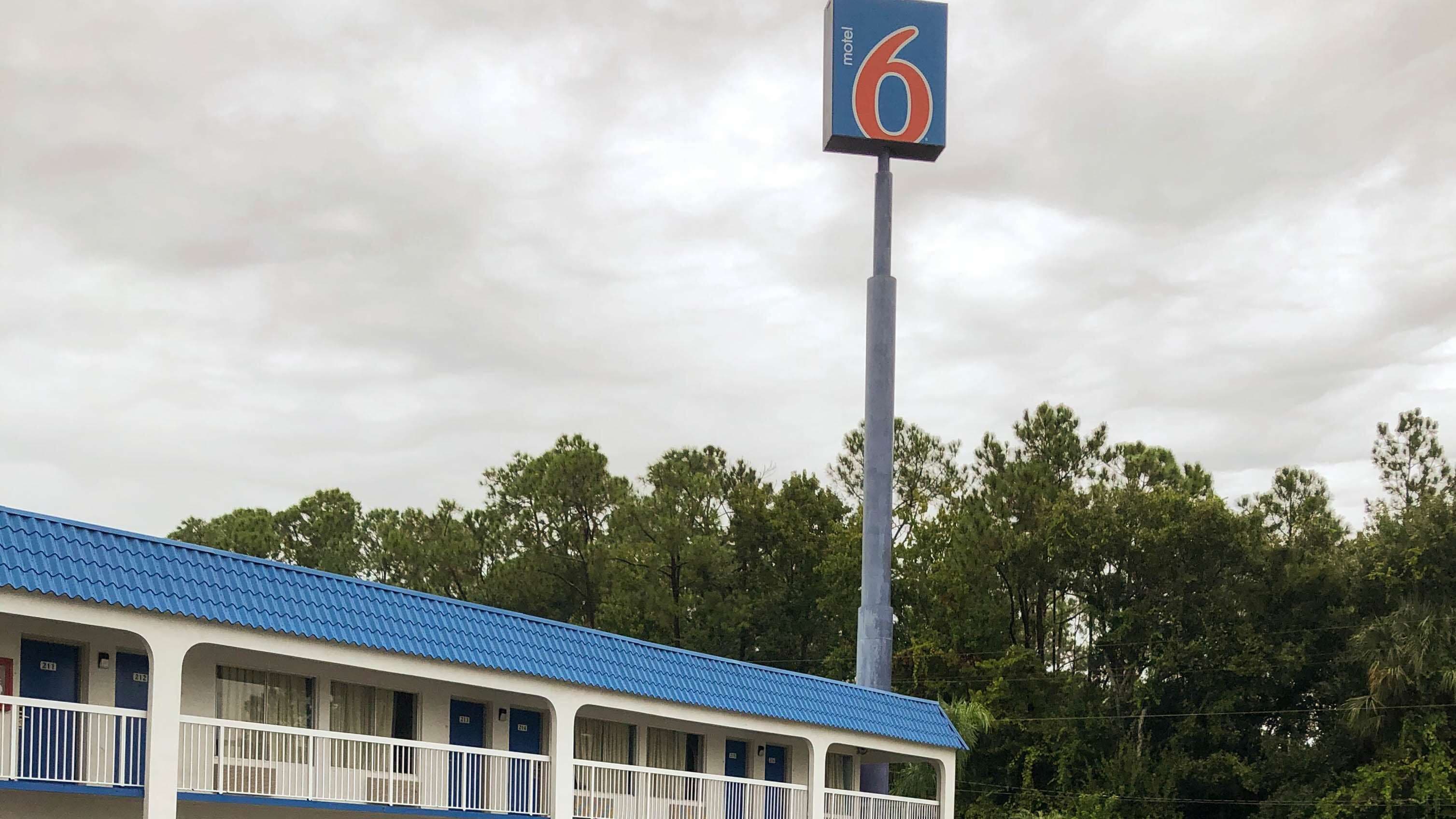 A motel with a blue roof and a sign indicating room number 6.