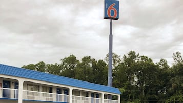 A motel with a blue roof and a sign indicating room number 6.