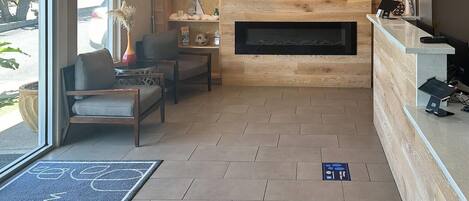 A reception area with a fireplace, seating, and a reception desk.