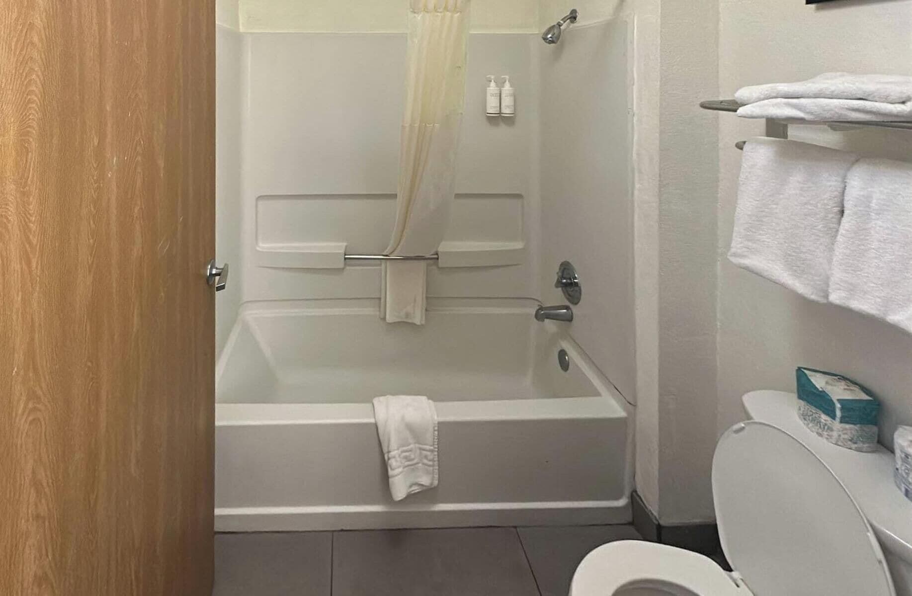 A bathroom with a bathtub, toilet, and towel rack.