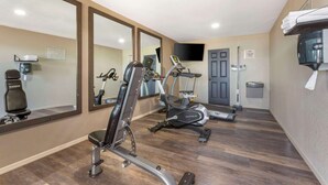A gym with cardio machines, a mirror, a TV, and a coffee machine. - Quality Inn Show Low (Show Low)