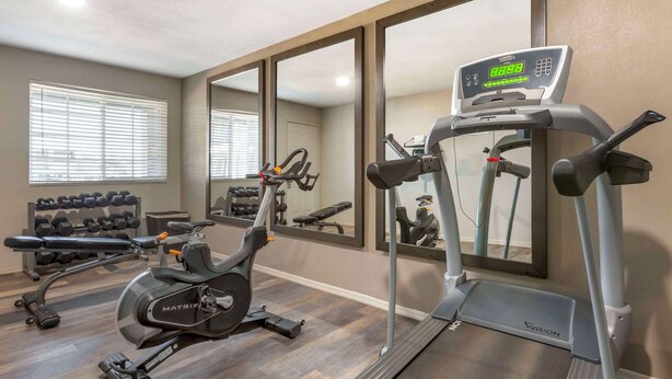 A gym with cardio equipment, dumbbells, and a mirror. - Quality Inn Show Low (Show Low)
