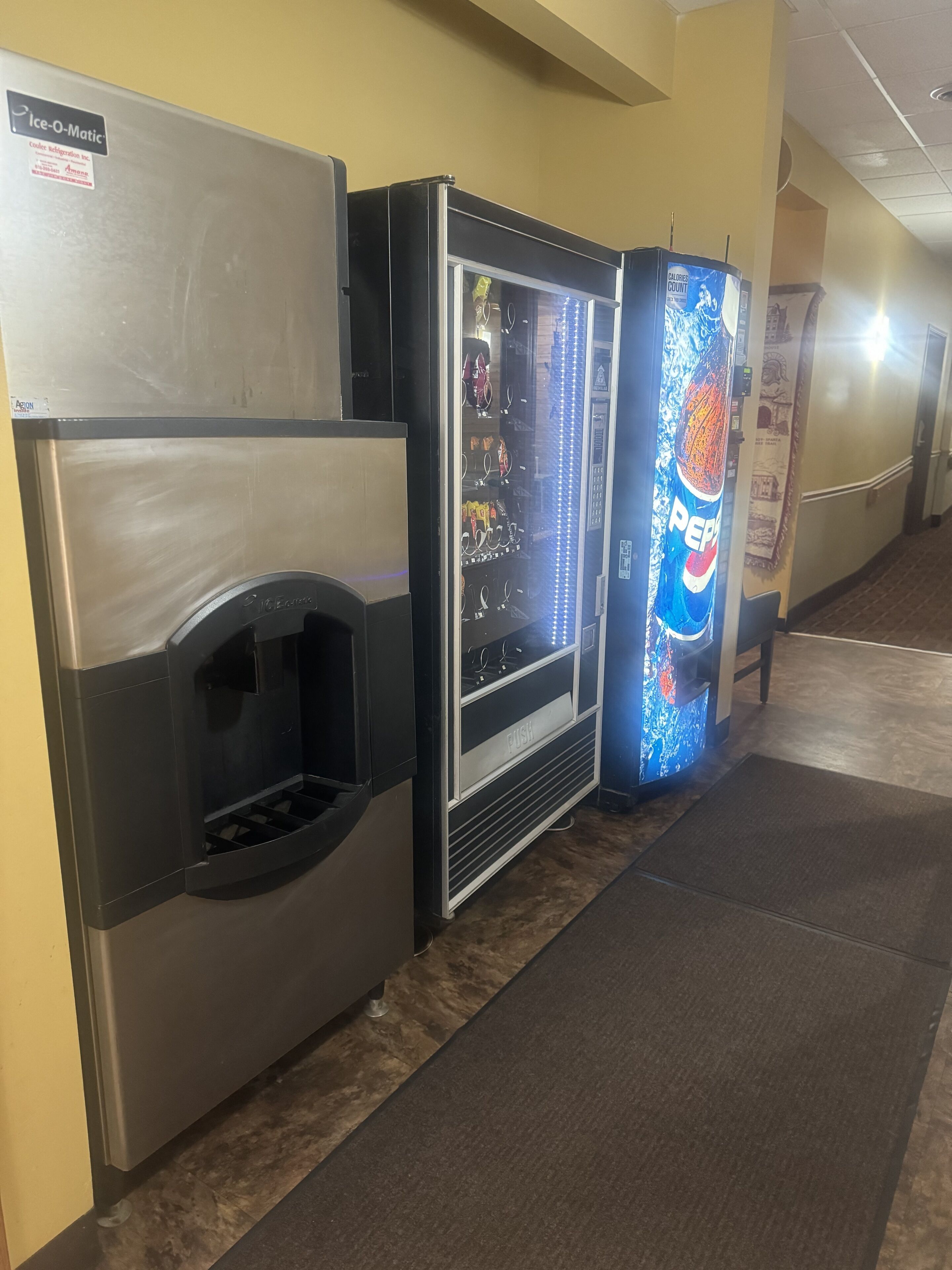 Zona de máquinas expendedoras con dispensador de Pepsi y dispensador de agua.