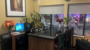 A conference room with a glass table, chairs, a laptop, and decorative plants. - Super 8 by Wyndham Sparta (Sparta)
