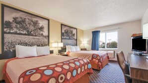 Een hotelkamer met twee bedden, een bureau, een stoel en een televisie.
