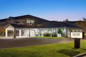 Un hotel llamado 'Garner' con un diseño arquitectónico moderno, que presenta una entrada cubierta y varios ventanales.