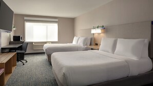 A hotel room with two beds, a desk, a TV, and a window with blinds. - Garner Hotel Salt Lake City Airport by IHG (Salt Lake City)
