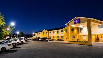 Un motel con un parcheggio, un edificio con il cartello che indica 'Blaine Tow Inn' e un ingresso ben illuminato.