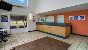 A reception area with a wooden counter, a large window, and a view of the outdoors.