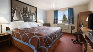 A hotel room with a large bed, a desk, a chair, a television, and a window with curtains. - Super 8 by Wyndham Bellingham Airport/Ferndale (Ferndale)