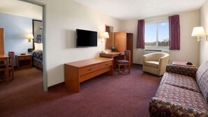 A hotel room with a desk, chair, sofa, and a large window. - Super 8 by Wyndham Bellingham Airport/Ferndale (Ferndale)