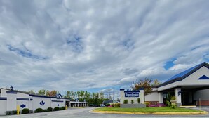 A Travelodge hotel with a modern design, featuring a covered parking area and a well-maintained lawn. - Travelodge by Wyndham Laurel/Ft. Meade/Near NSA (Laurel)