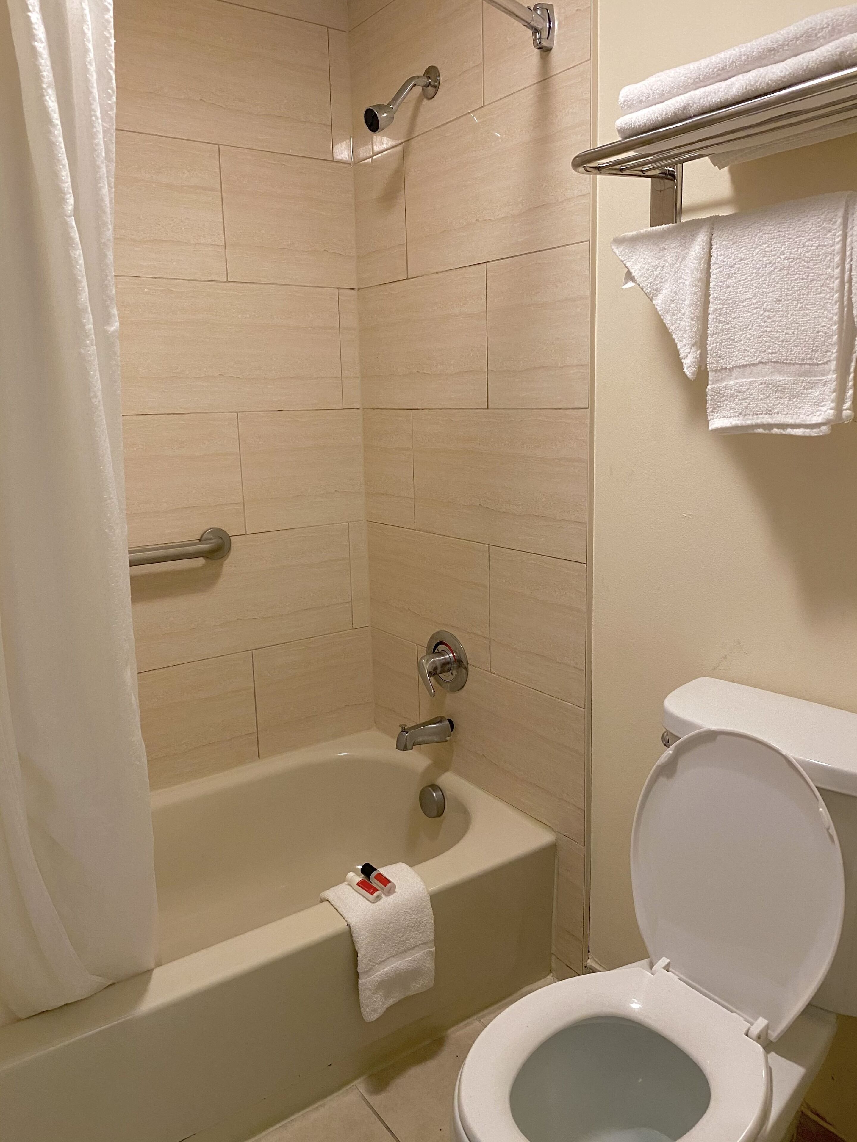 A bathroom with a bathtub, shower, and toilet.