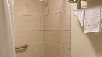 A bathroom with a bathtub, shower, and toilet.