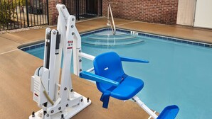 A pool with a blue chair and a white exercise machine.